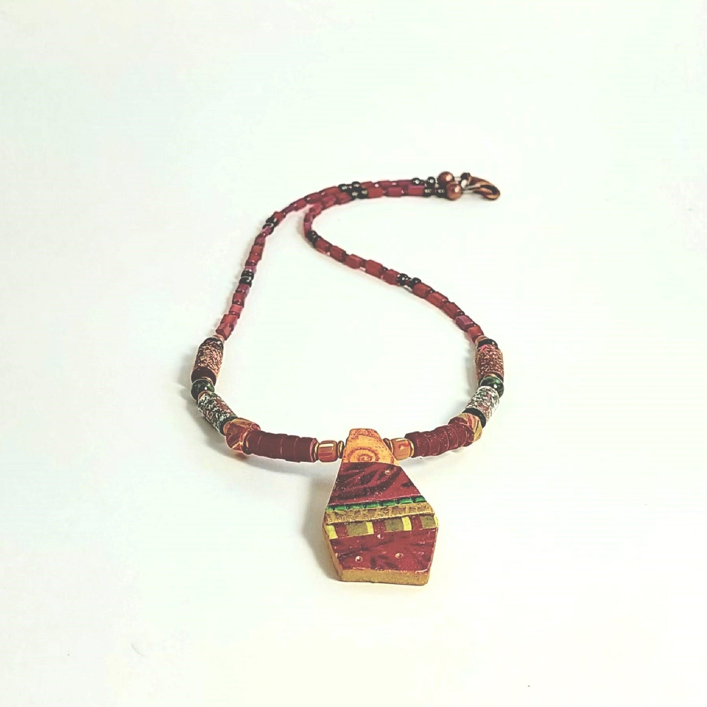 Frontal view of pendant suspended between texture tube beads and cranberry heishi, accented with cranberry and dark green seed beads. Finished with a copper lobster clasp. Very lightweight. Free shipping in the US.