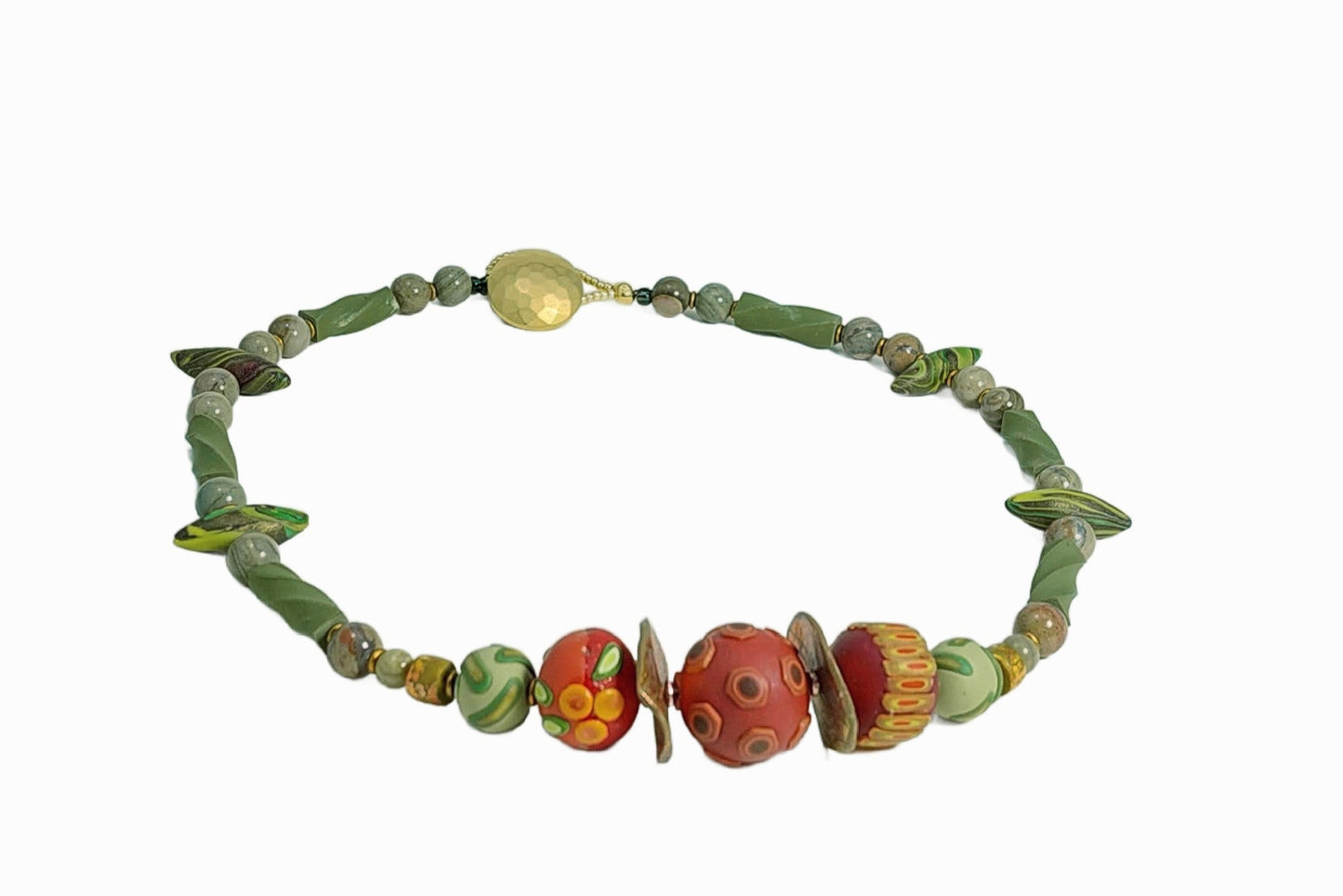 Frontal view of Sage and Spice Necklace. Three russet hued focal beads have surface details of berries, leaves, and pods. Accents include round beads, twisted logs, and small pods in varying shades of muted green, silver leaf jasper gemstone beads, and matte gold disks. Loop and button closure. A versatile necklace to wear to the office and a night out! Lightweight. Free shipping in the US.