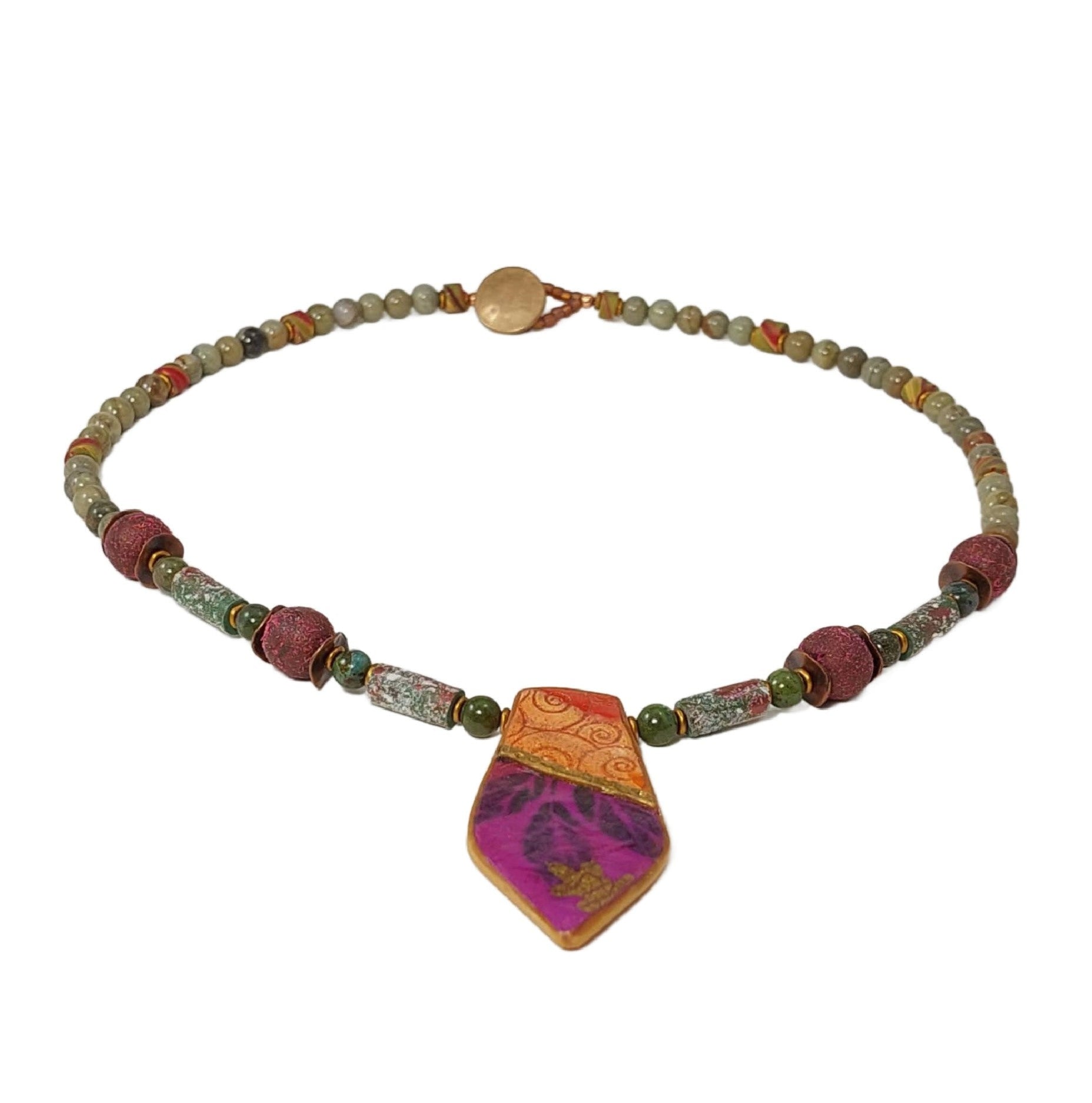 Geometric collaged polymer pendant with areas of embossed clay and image transfers of leaves, gold leaf details. Accented with silver leaf and green jasper gemstone beads, copper wavy disks, matte gold disks, iridescent polymer tube beads and textured round beads. Button and loop clasp. 20 inches long. Free shipping in the US.