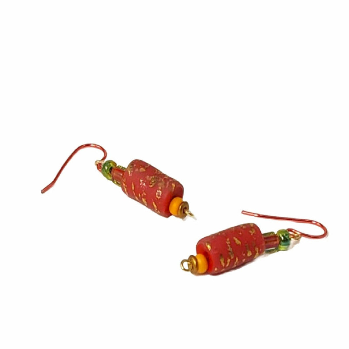 Pair of bright terracotta and gold earrings on a white background