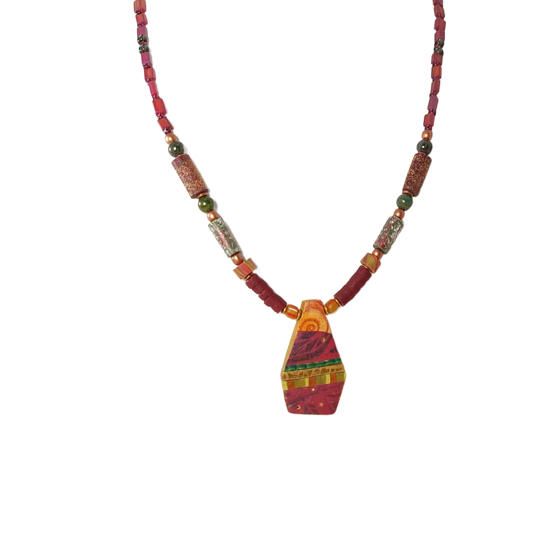 Geometric collaged pendant necklace detailed with swirls, subtle leaf designs, geometric patterns, and gold leaf. Pendant rests between  textured tube beads, marbled disks, and heishi beads. Copper beads and green jasper gemstone beads add accents. Very lightweight on body. Twenty inches long, copper lobster clasp. Free shipping in the US.