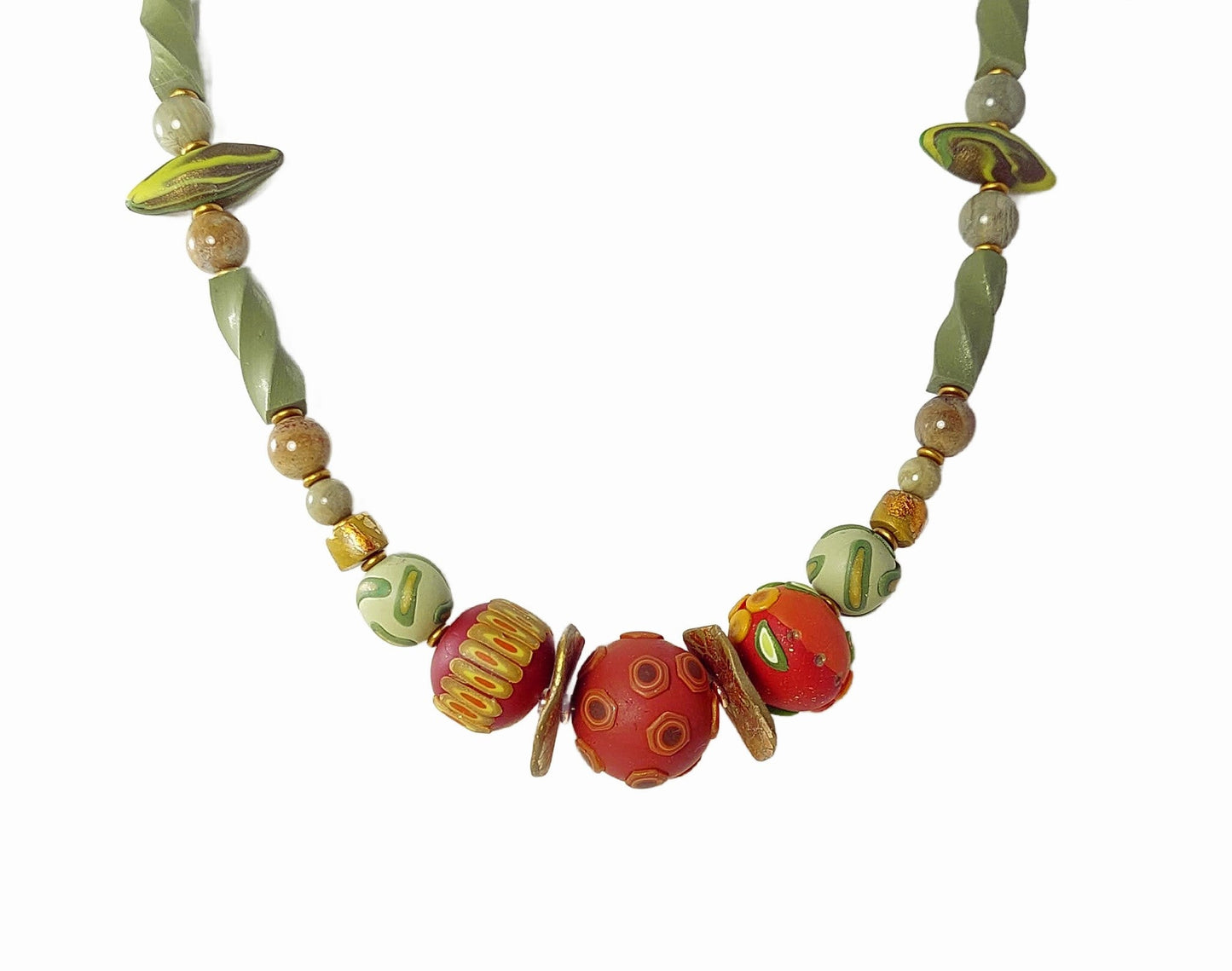 The elegant Sage and Spice Necklace features three russet hued focal beads detailed on surface with a mix of leaf, berry, and pod shapes. Accented with a mix of green polymer clay beads, silver leaf jasper gemstone beads, and matte gold disks. Button and loop closure. Lightweight. Free shipping in the US.