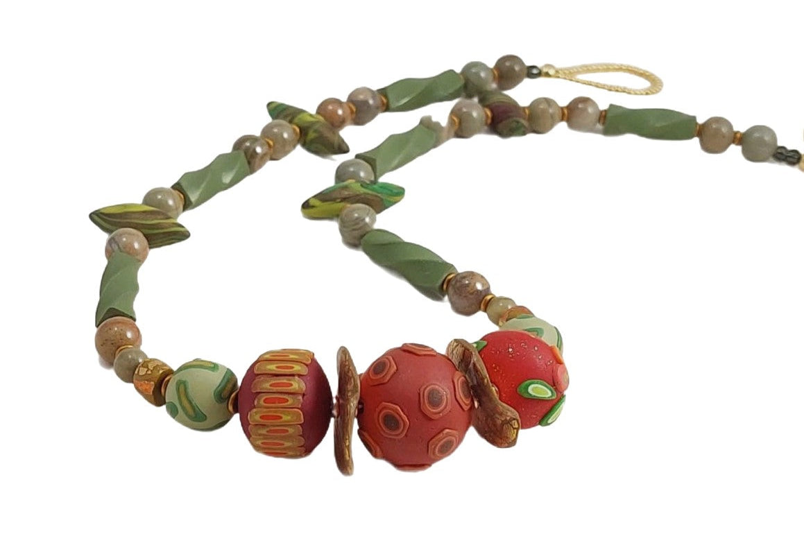 Sage and Spice Necklace features three russet hued focal beads have surface details of berries, leaves, and pods. Accents include round beads, twisted logs, and small pods in varying shades of muted green, silver leaf jasper gemstone beads, and matte gold disks. Loop and button closure. A versatile necklace to wear to the office and a night out! Lightweight. Free shipping in the US.