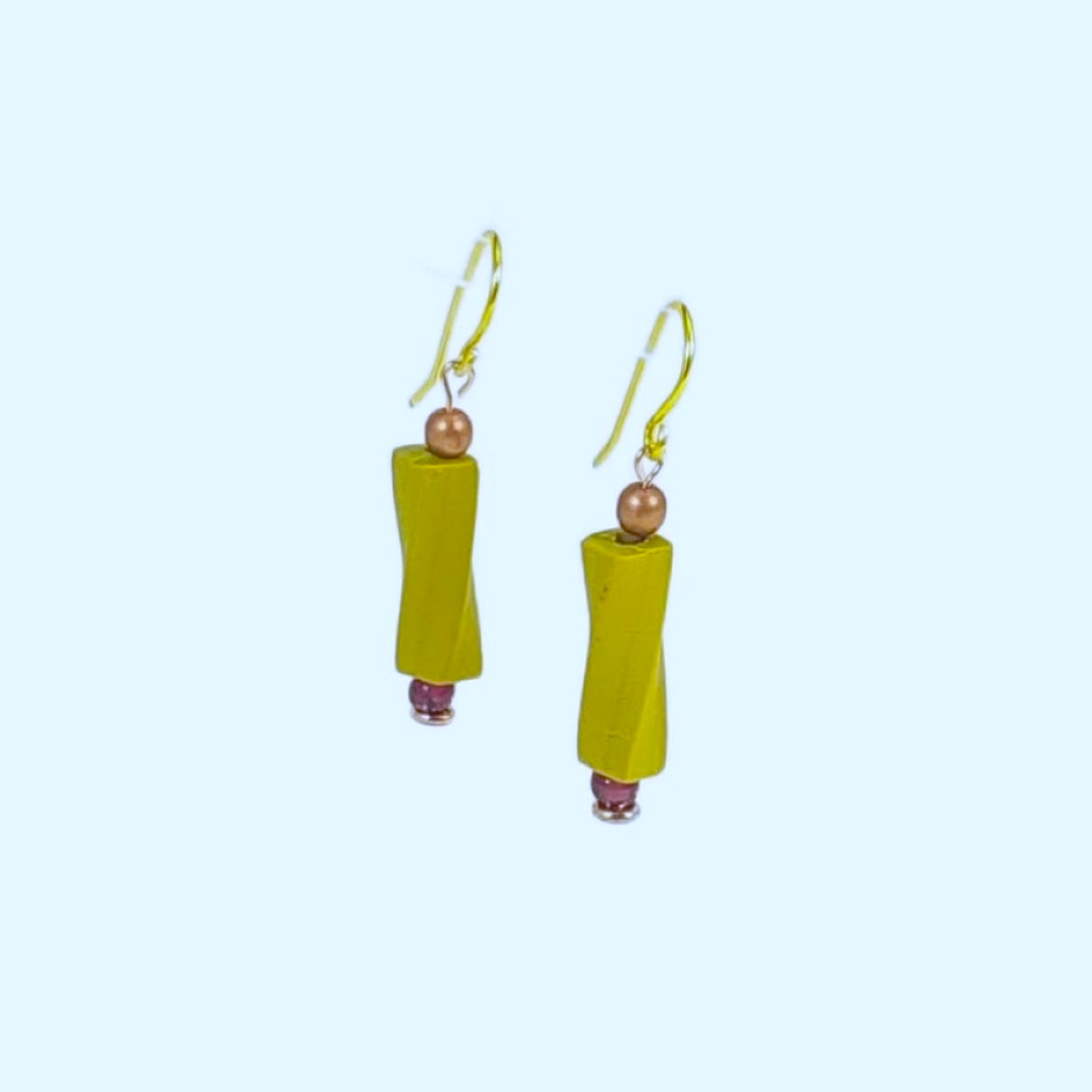 Pair of chartreuse earrings with cylindrical beads on a light blue background