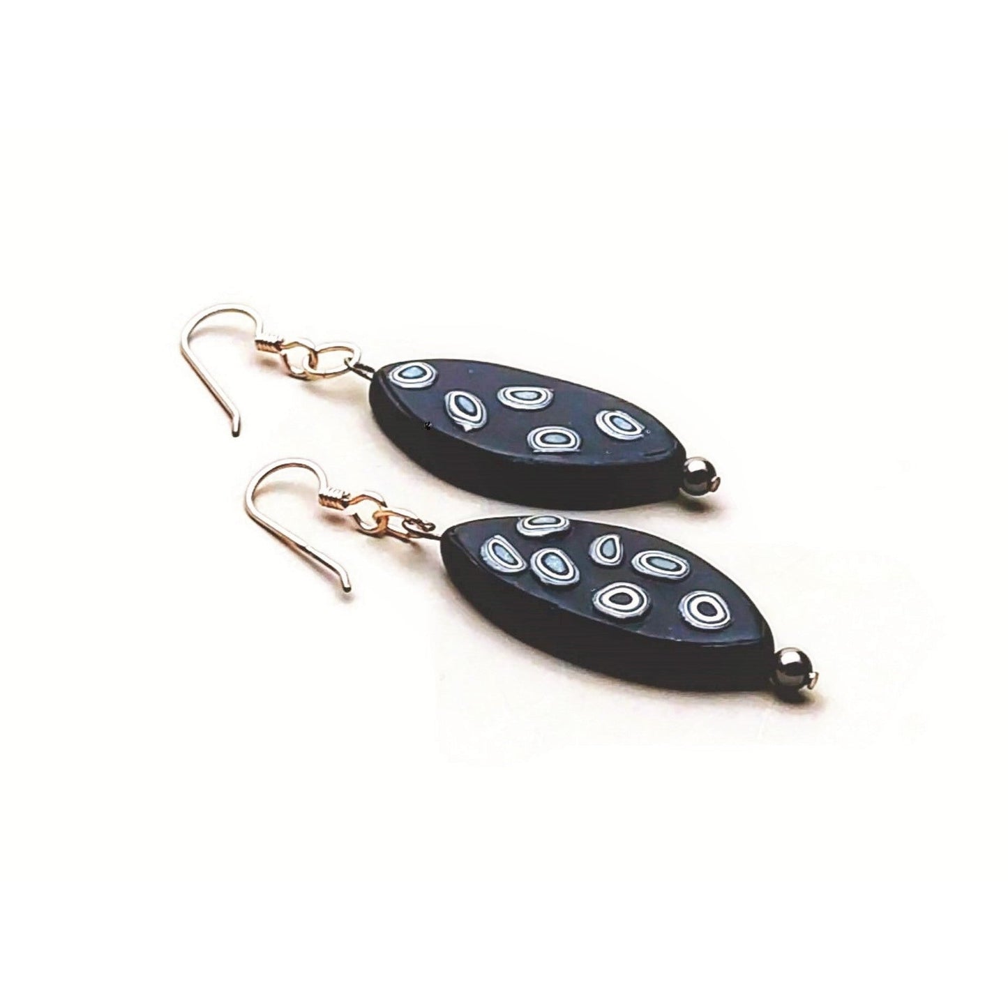 Reverse side of elliptical polymer clay earrings on white background