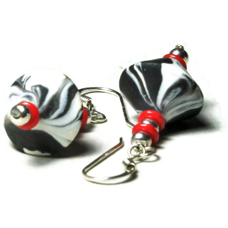 Closeup of polymer clay bicone earrings with sterling silver ear wires on white background