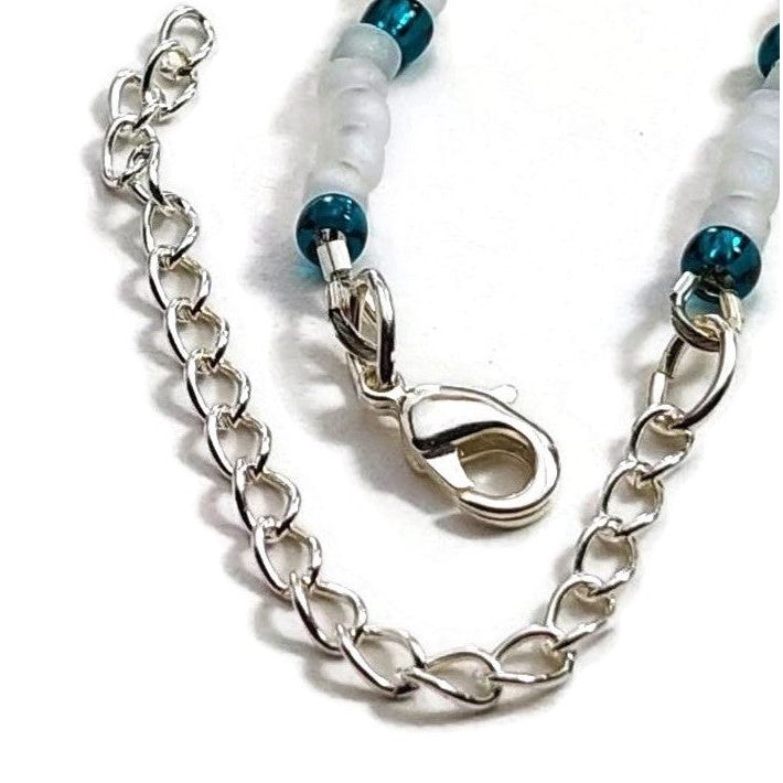 Detail of sterling silver lobster clasp and extension chain on white background