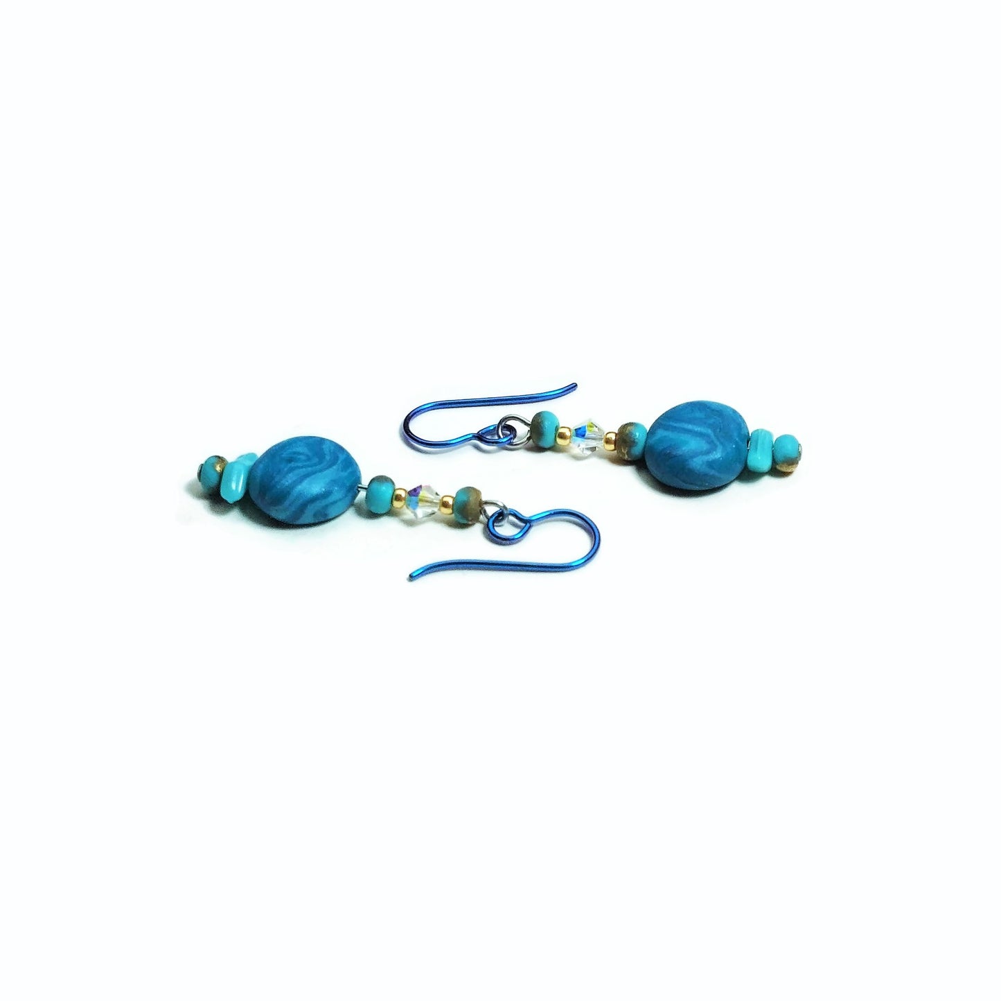 Polymer clay disk bead drop earrings with teal niobium ear wires on white background