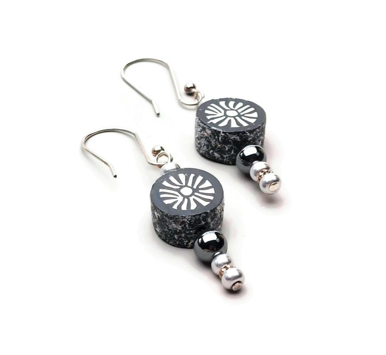 Polymer clay sunburst disk and hematite gemstone drop earrings with sterling silver ear wires on white background