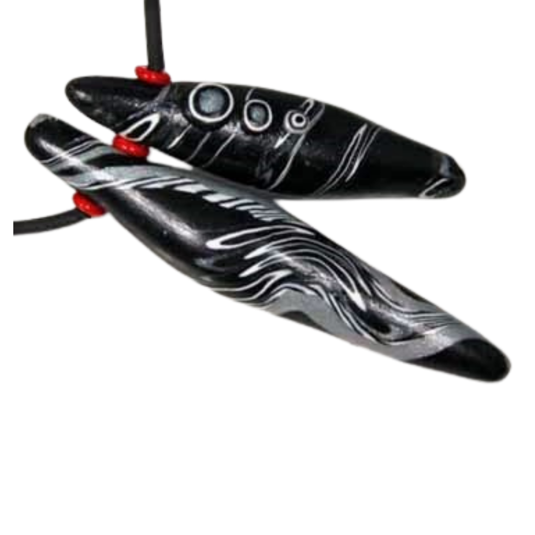 Two black polymer clay pod-shaped beads with white  and silver swirl patterns and red spacers on a black cord, shown against a plain white background