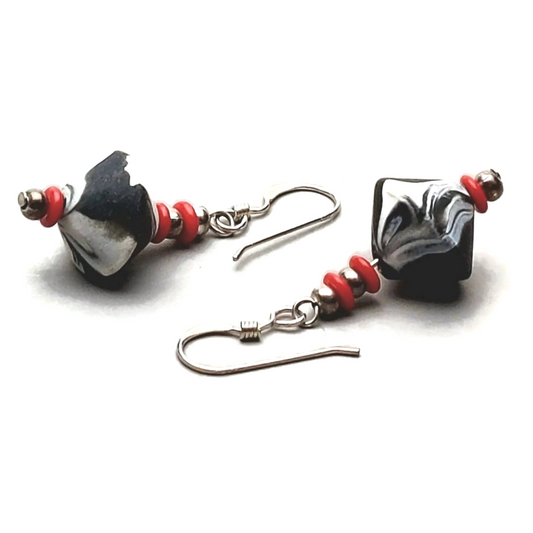 Pair of marbled black and white bicone earrings with red bead accents and sterling silver ear wires.
