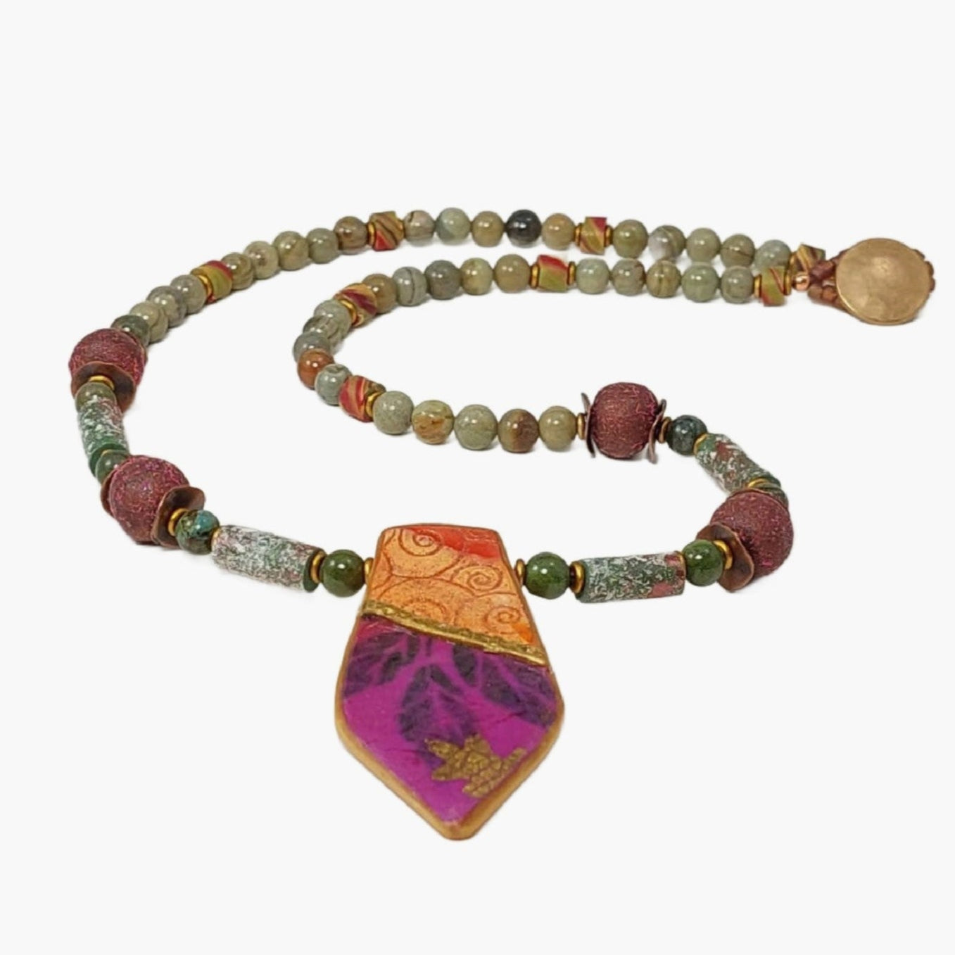 Geometric collaged polymer pendant with areas of embossed clay and image transfers of leaves, gold leaf details. Accented with silver leaf and green jasper gemstone beads, copper wavy disks, matte gold disks, iridescent polymer tube beads and textured round beads. Button and loop clasp. 20 inches long.Free shipping in the US.