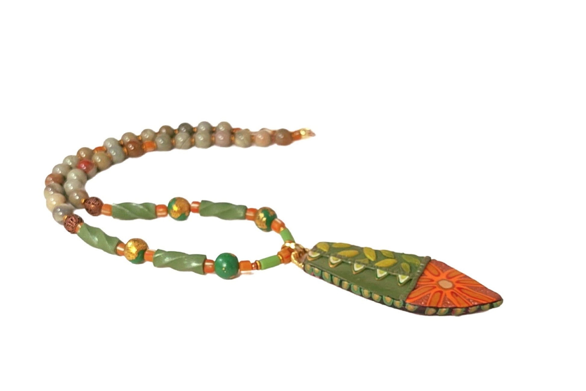 Decorative pendant  with leaves and a  flower surrounded by polymer clay and jasper gemstone beads.