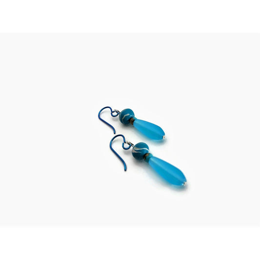 Turquoise polymer clay and glass bead drop earrings with teal niobium ear wires on white background