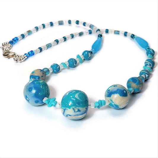 Polymer clay and glass bead necklace with silver-filled lobster clasp on white background