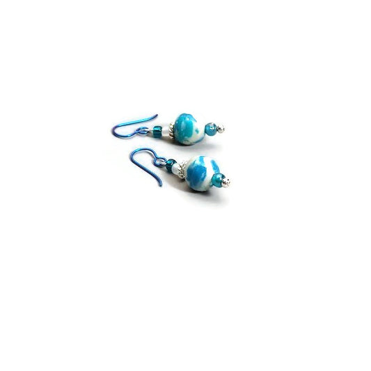 Polymer clay marbled drop earrings with teal niobium ear wires on white background