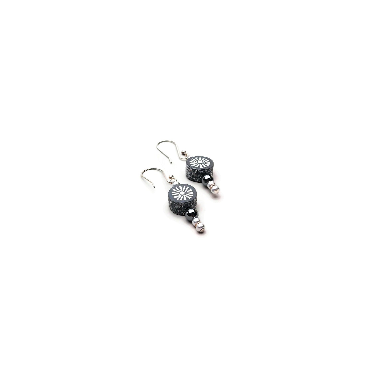 Polymer clay sunburst disk and hematite gemstone drop earrings with sterling silver ear wires on white background